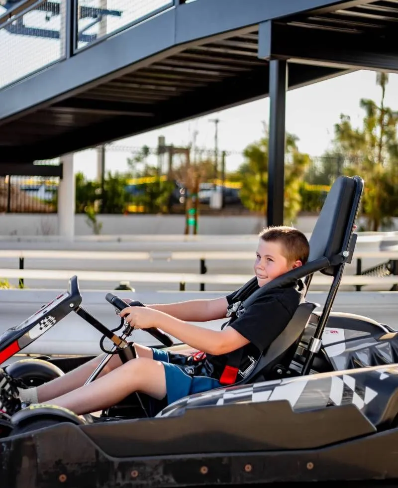 Child driving a go-kart under the canopy on the Pecan Lake track